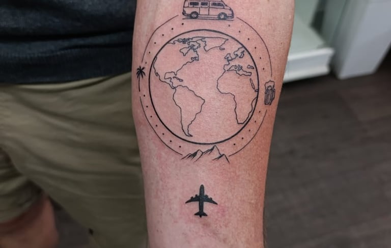 Man's arm tattoo of a plane flying over a globe.  Tattooed at Katarsis Studio in Lima
