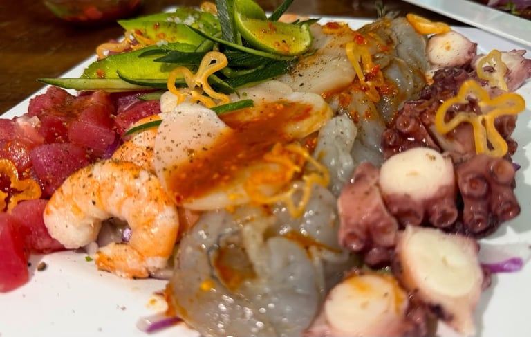 Plato de mariscos mexicanos frescos que incluye camarón crudo, pulpo, atún, aguachile de camarón