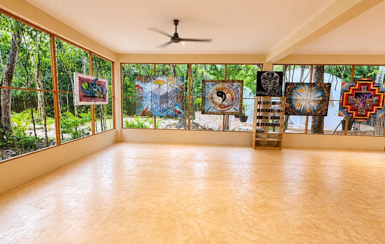 A spacious multi-purpose space, with large windows, thoughtful artwork decorating the place, overloo