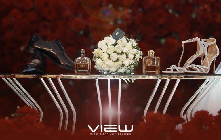 Wedding accessories including bridal shoes, groom's dress shoes, perfume, and a white rose bouquet.