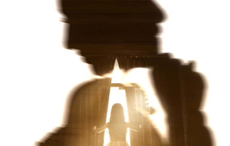 Double exposure silhouette of a bride in a wedding gown standing by a window with bright light.