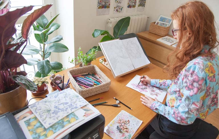 a woman sitting at a desk drawing