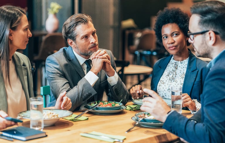 a group of people sitting at a table with food
