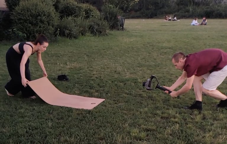 two people are filming a marketing ad using a gimbal and yoga mat