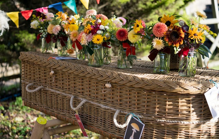Wicker funeral casket decorated with fresh flowers