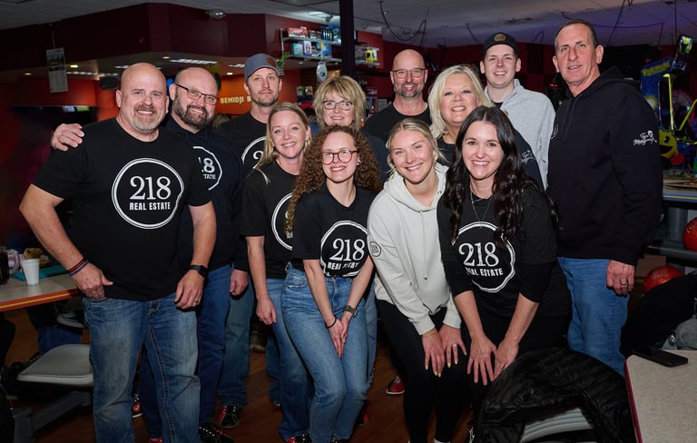 a group of people standing next to a bowling lane