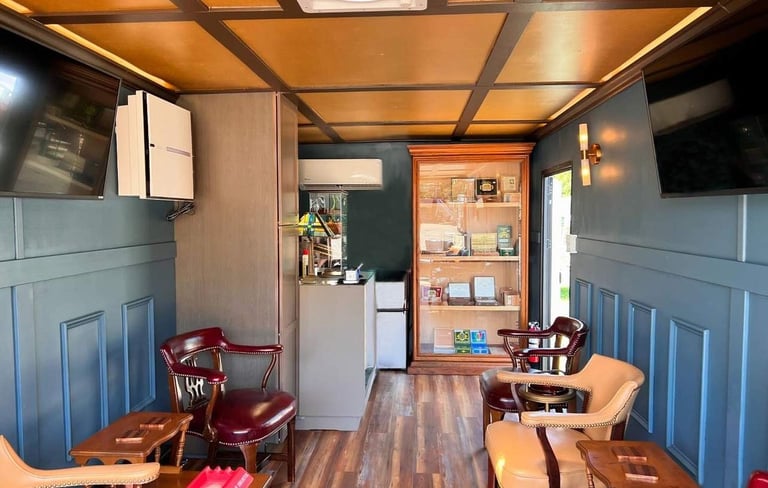Inside view of our mobile cigar lounge showcasing our humidor, smoke eater and big-screen TVs.