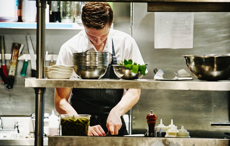 a man in a kitchen preparing food in a kitchen