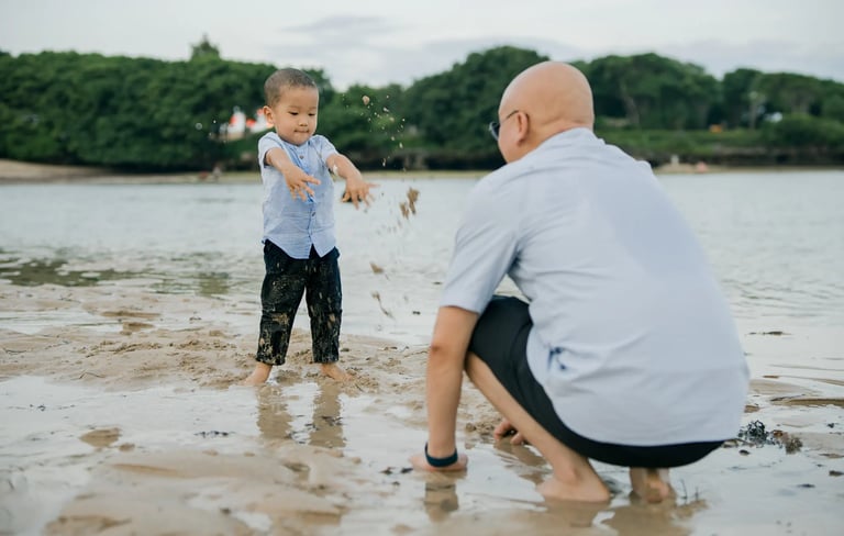 Father playing with his son by the shoreline during a family photography session at Nusa Dua Beach