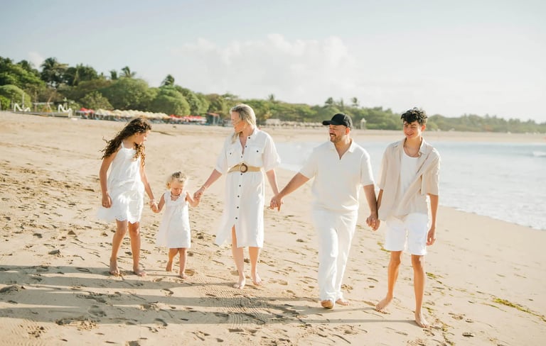 Family walking together along the shoreline during a family photography session at Ayodya Resort Bali