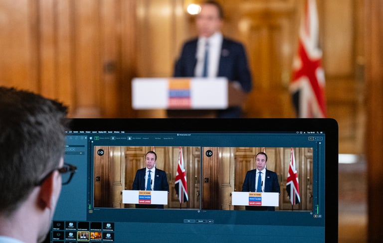 a man in a suit and tie is looking at a laptop screen