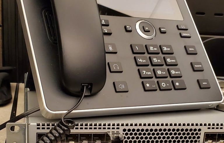 VoIP desk phone on top of a network device