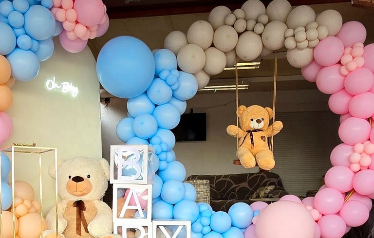 Decoración temática para fiesta de revelación de género con un arco de globos en colores pastel azul