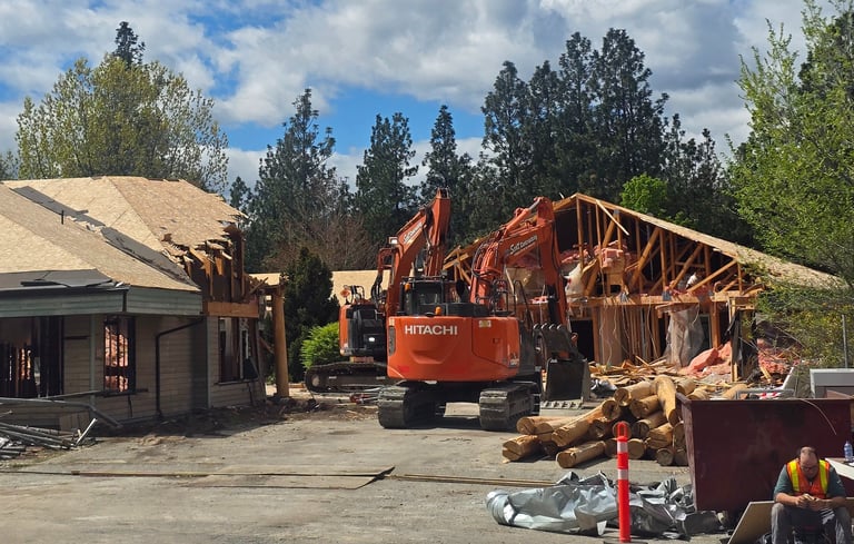 Two excavators demolishing a large structure