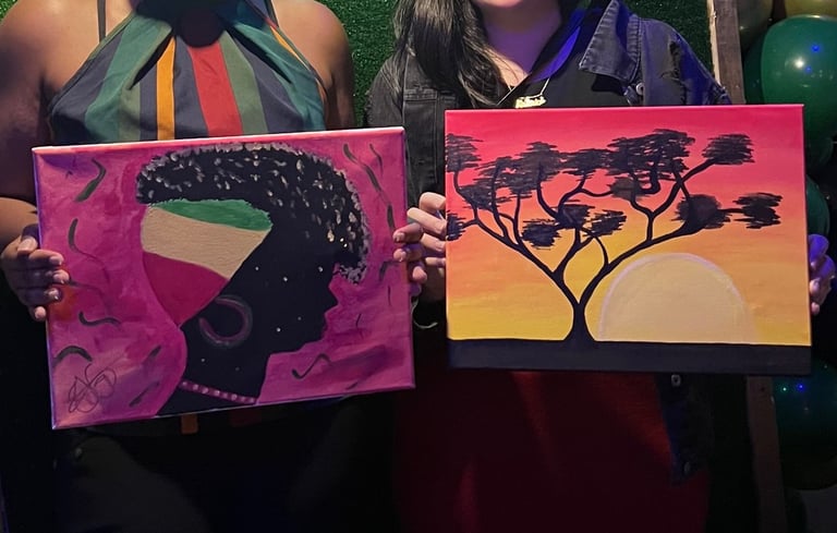 two women holding up their paintings in front of a green wall