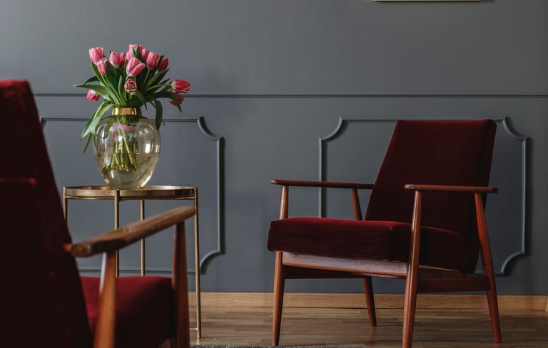A warm, softly lit consultation room in Calgary with two chairs angled toward each other, a small plant, and a notepad