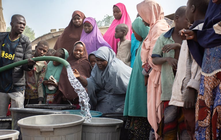a group of women collecting water from a water tanker