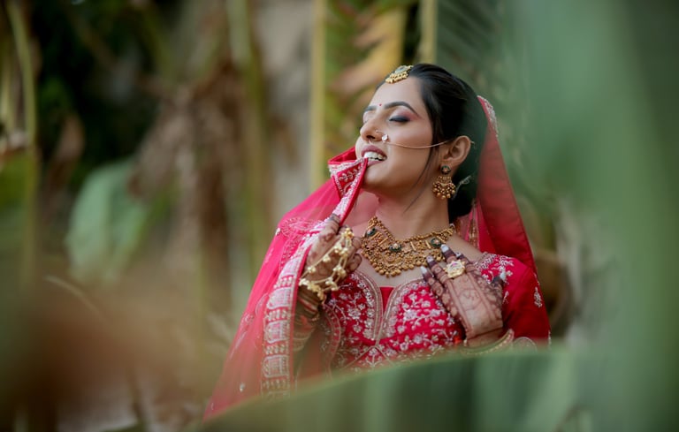 Close-up of joyful Indian dulhan in red bridal choli and jewellery during wedding photoshoot in Vado