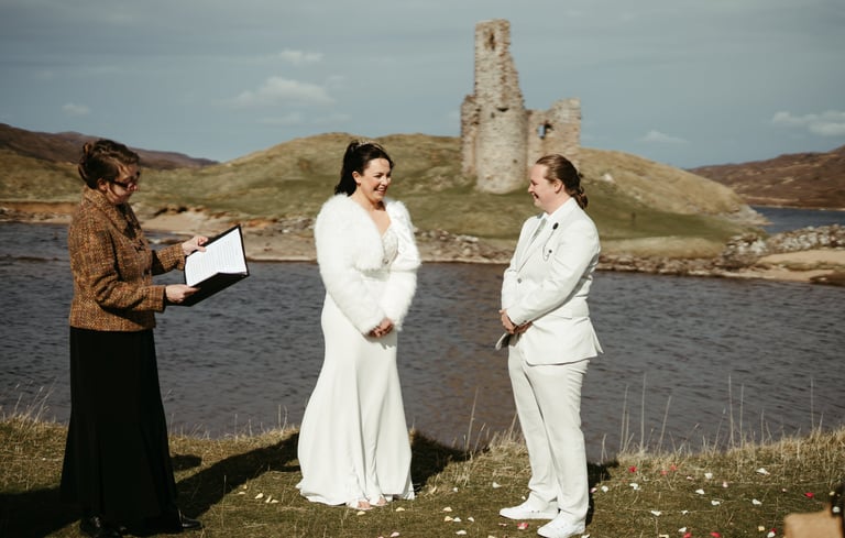 two brides in front of a Highland castle