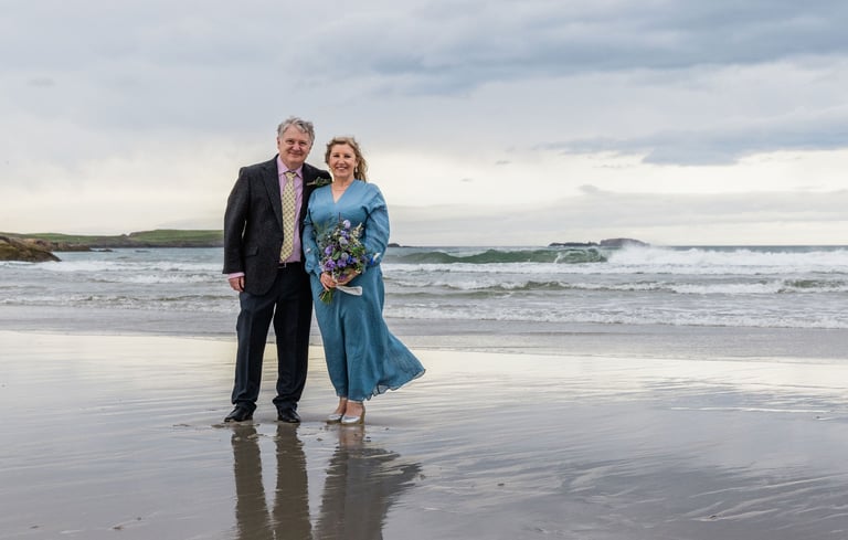 a man and woman standing on a beach after a wedding