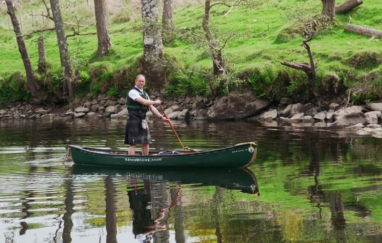 a man in a green canoe on a river
