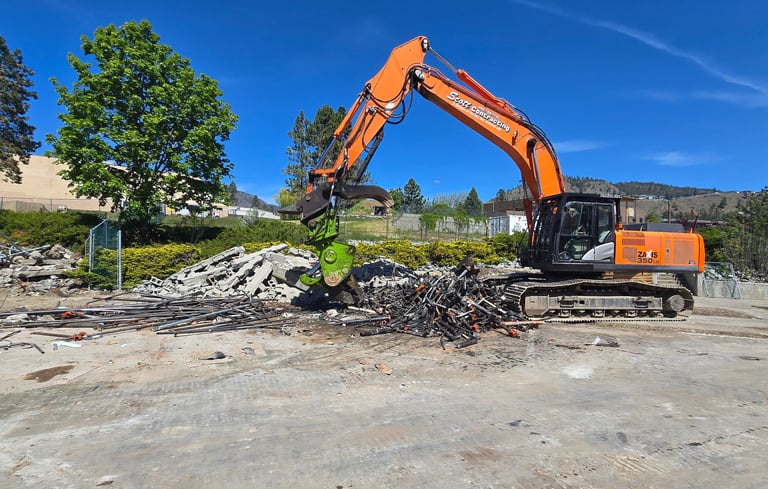 Excavator with a shear attachment cutting scrap metal