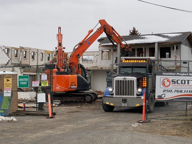 excavator loading a dump truck with debris