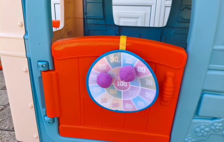 Análise do alvo de dardos com bolas de velcro na porta da casinha infantil Feber Casual House.