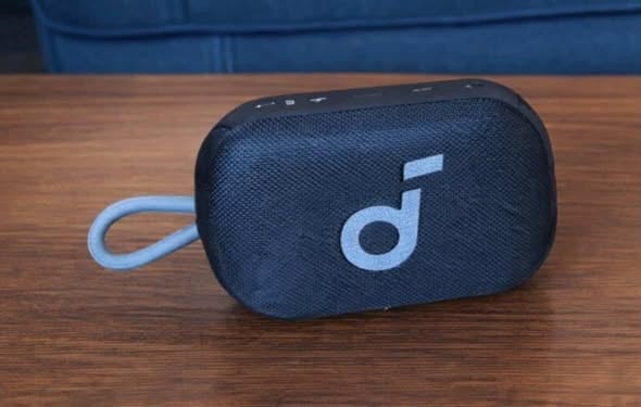 Portable Bluetooth speaker with loop strap on wooden table