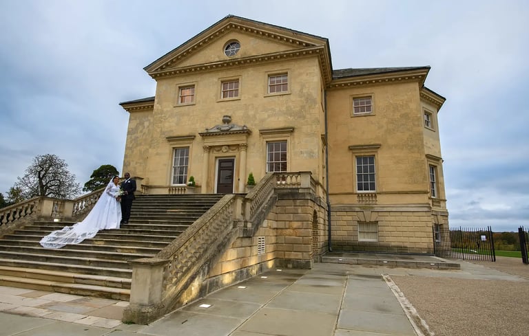 Newlywed couple posing on the stone stairs of Danson House wedding venue.