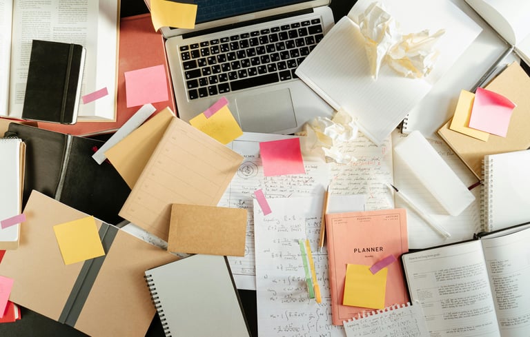 A desk with a notebook open, several pages filled with notes, suggesting deep consideration rather than rushed activity.
