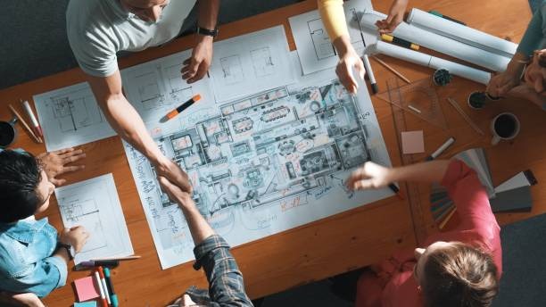 home builders and customer looking over blueprints for new home