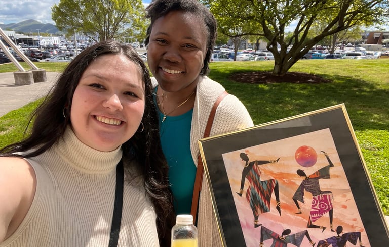 a woman holding a picture of a painting
