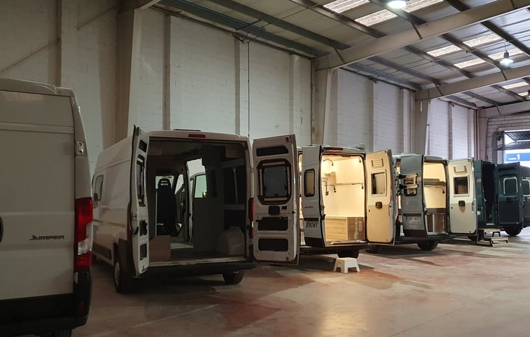 Interior del taller de innovans donde aparecen distintas furgonetas en proceso de camperizacion