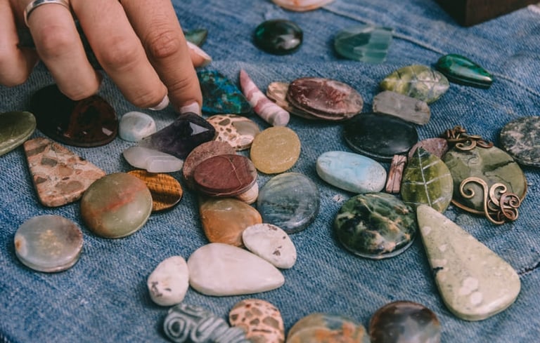 Seleccionando a mano piedras preciosa mexicanasy cristales curativos dispuestos sobre tela vaquera a
