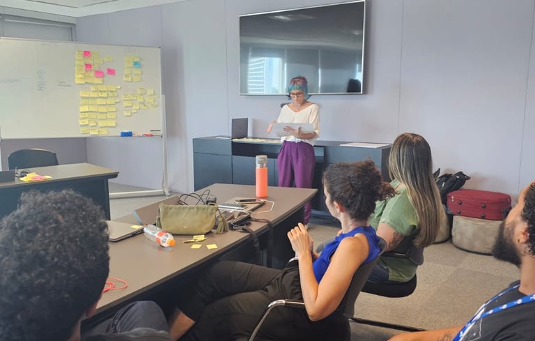 Gabriela Bechara Zillig conduz dinâmica de Design Sprint em uma sala de reunião para colegas