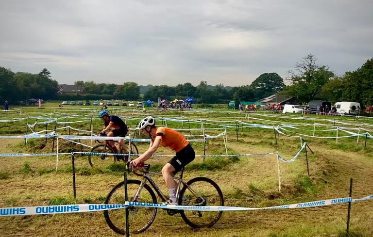 a cyclist riding a bike around a corner on a cyclocross course