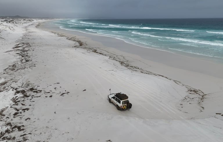 Toyota Land Cruiser 4x4 rijdend over een afgelegen strand in West Australië