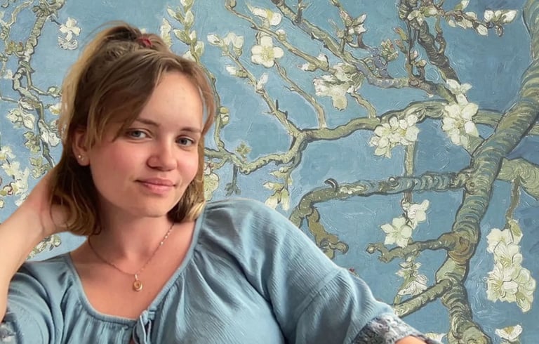 anglų ir prancūzų kalbų mokytoja sėdi gėlių pilname fone