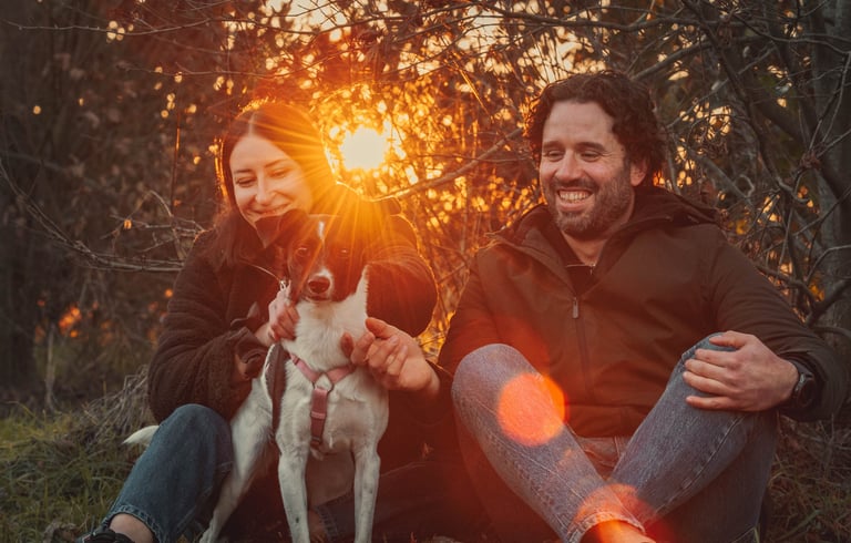 ragazza e ragazzo con cane al tramonto