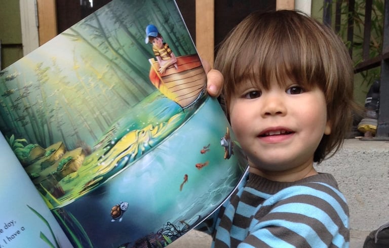 a young boy is holding a book in his hands