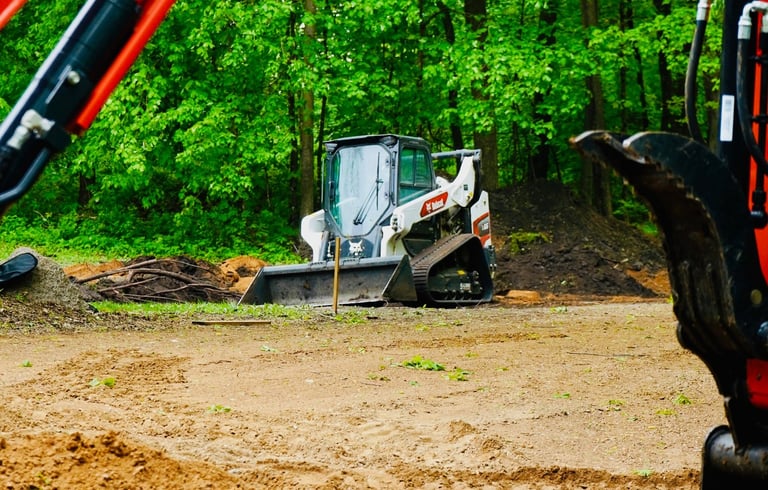 bobcat skid steer grading gravel lot in central mn