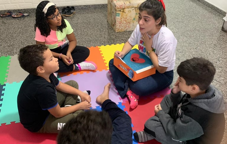 a group of children sitting on a floor with a teacher