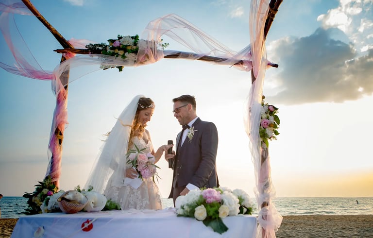 una sposa e uno sposo in piedi davanti a una cerimonia nuziale in spiaggia