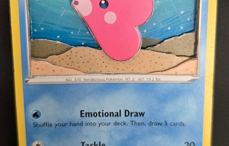 A 3D shadowbox paper craft of a pink Luvdisc Pokémon card with layered underwater scenery.