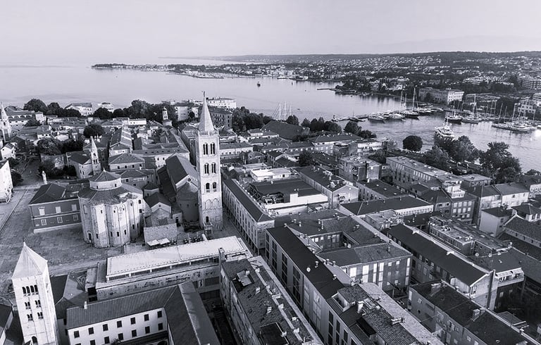 A bird view photo of Zadar peninsula, with the Church of St. Donatus, The Cathedral and Bell Tower