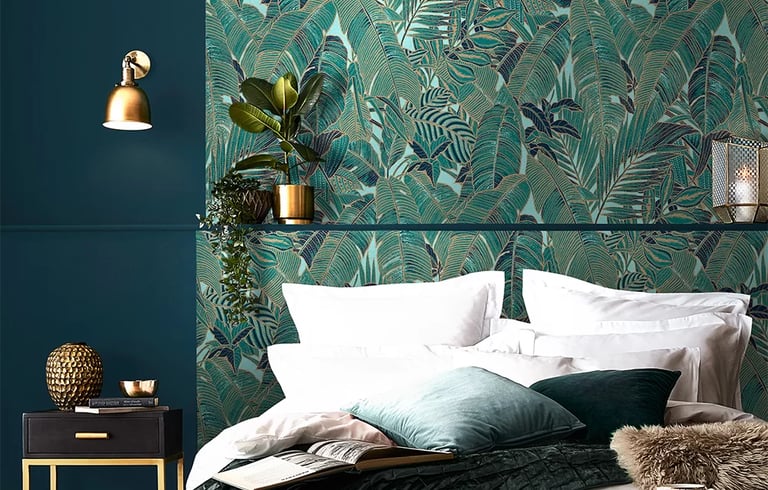 Elegant bedroom featuring tropical teal palm leaf wallpaper and luxury gold decor accents.