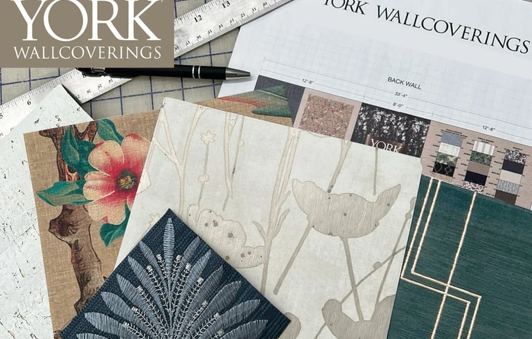 York Wallcoverings designer wallpaper samples with floral and geometric patterns on a project planning desk.