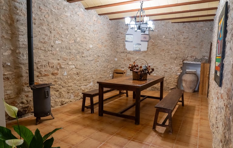 Sala de reuniones con mesa de madera en la planta baja de Carmens Rural, Sant Jordi