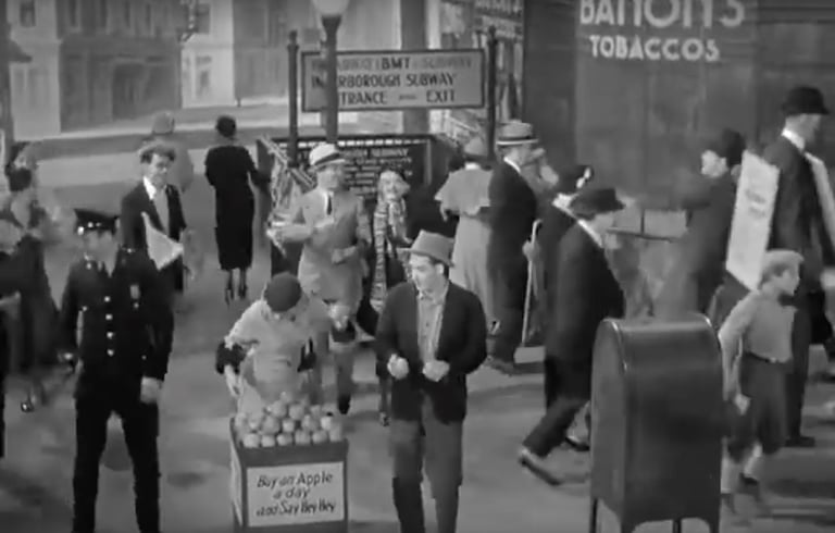 Street scene from 42nd Street (1933) finale with vendors, police, and Depression‑era city life.
